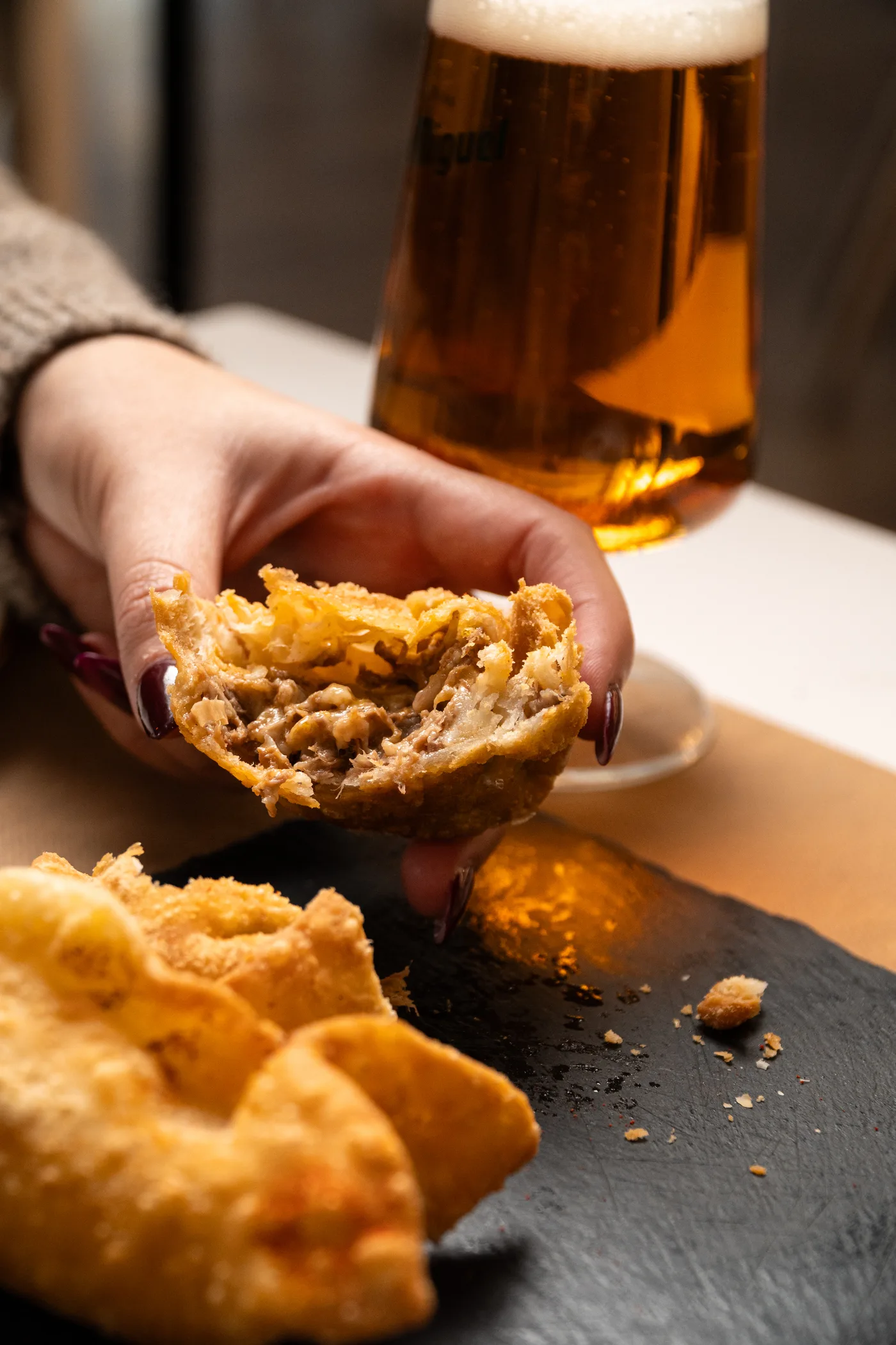 Empanada de carne recién abierta, con una caña de fondo
