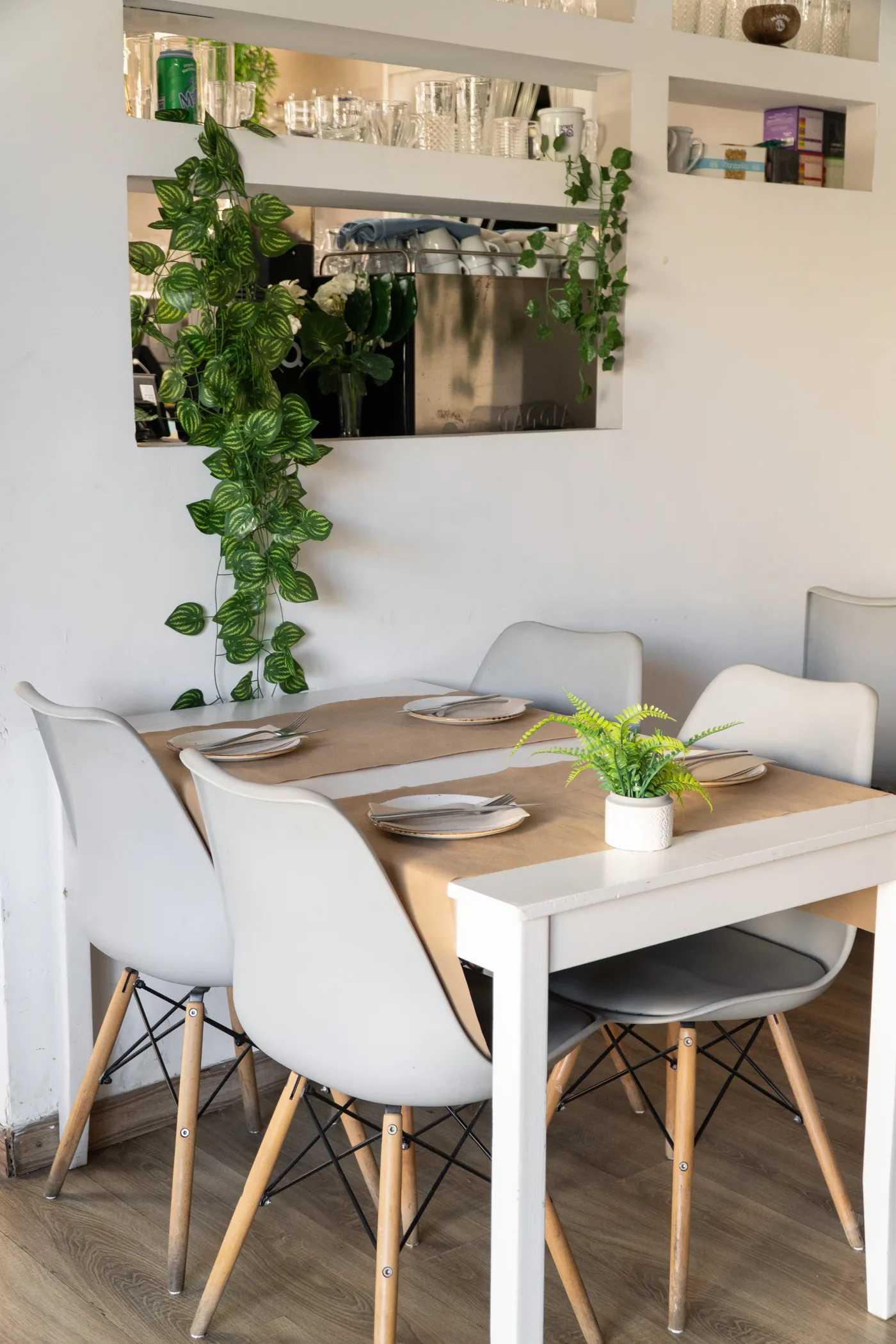 Mesa del salón puesta para cuatro, entre plantas