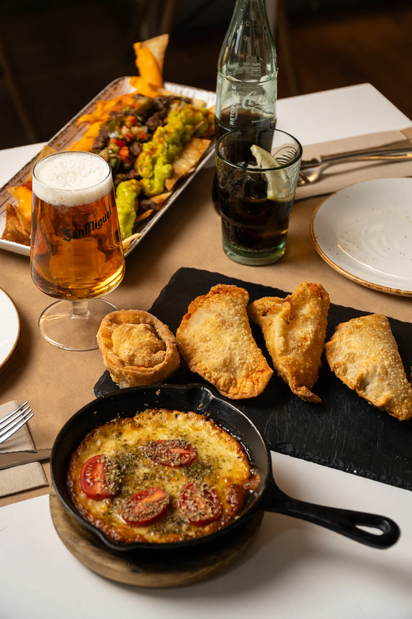 Mesa compartida con empanadas, provoleta y nachos con carne