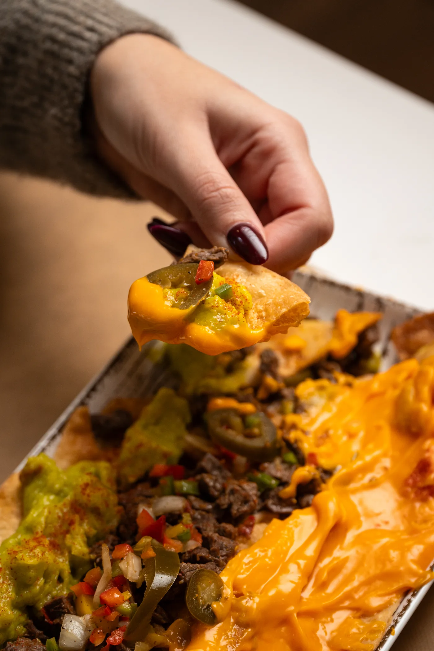 Nachos con carne, cheddar, guacamole y jalapeños