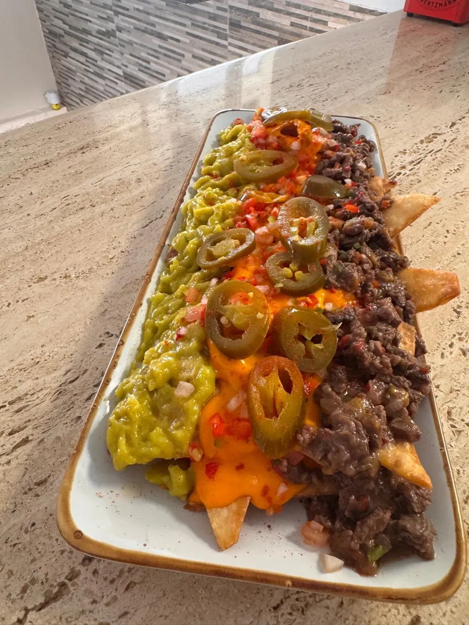 Nachos con carne, guacamole y jalapeños