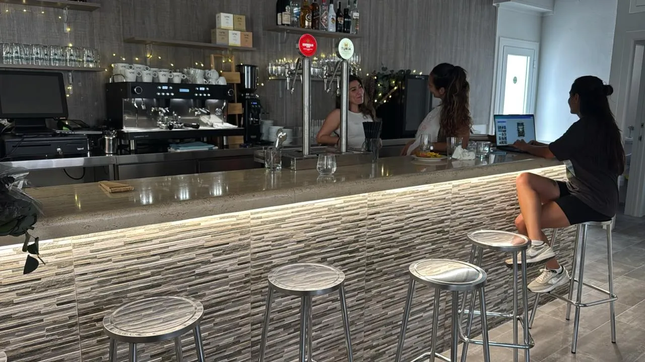 Barra del bar con taburetes y cafetera